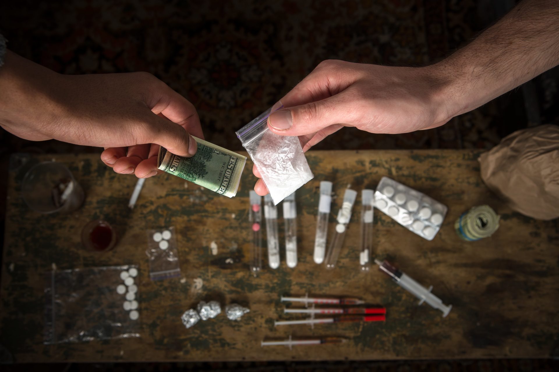 Drug paraphernalia with syringe on the table.