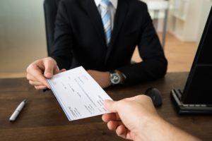 Cashier receiving check for payment.