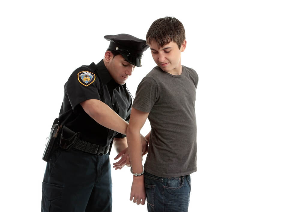 Teen boy arrested by the police.