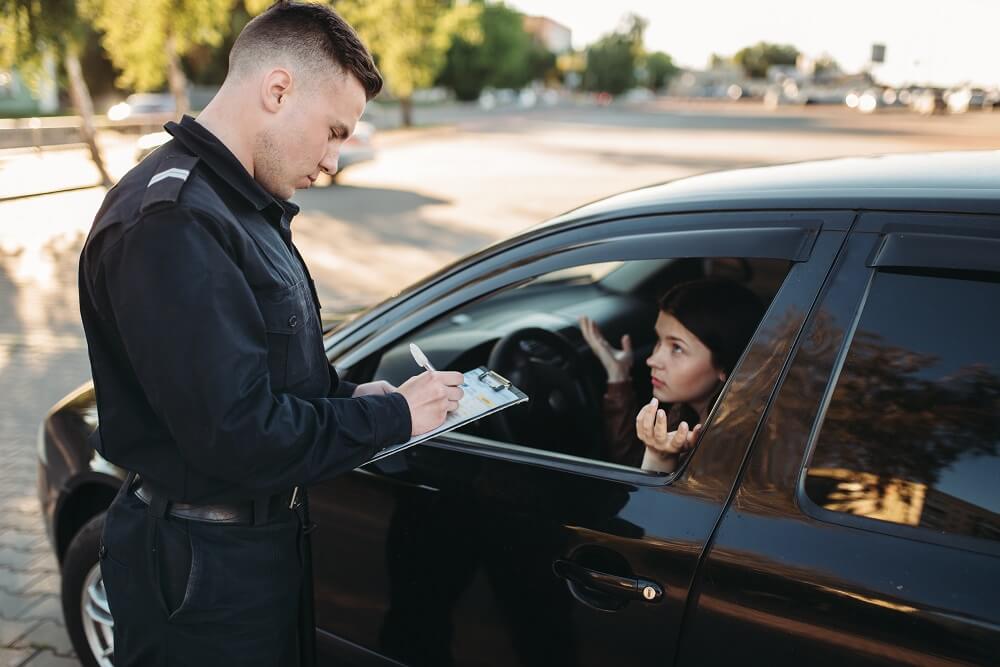 Young lady driver under probationary license issued ticket by police officer.