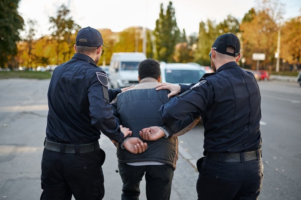 Police officers arresting criminal in entrapment operation.