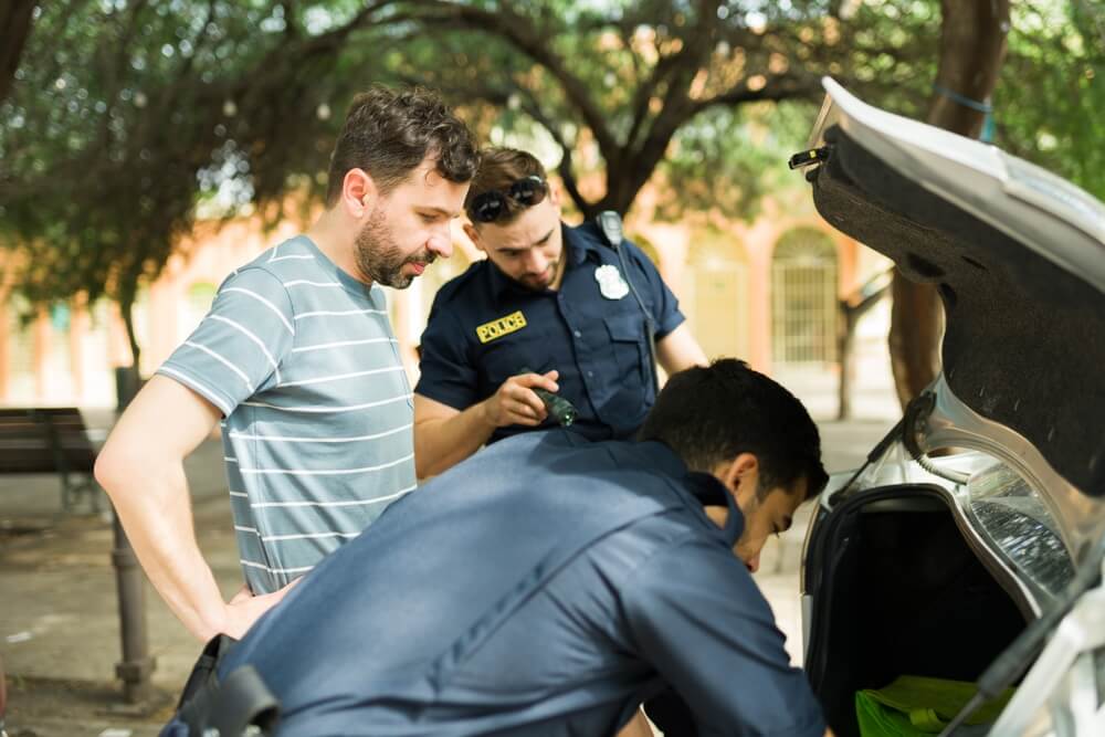 Police officers searching in the car for dangerous drugs.