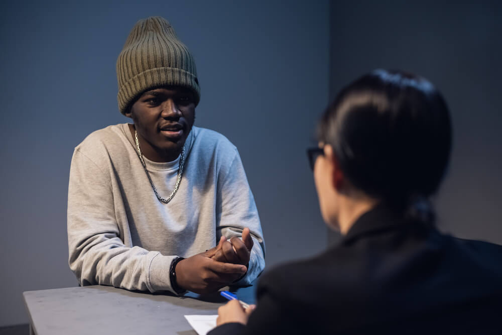 Young black man as first time offender talking to his lawyer.