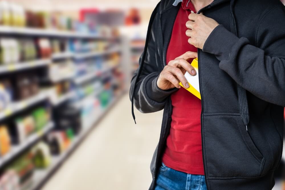 Man shoplifting gadget from the department store.